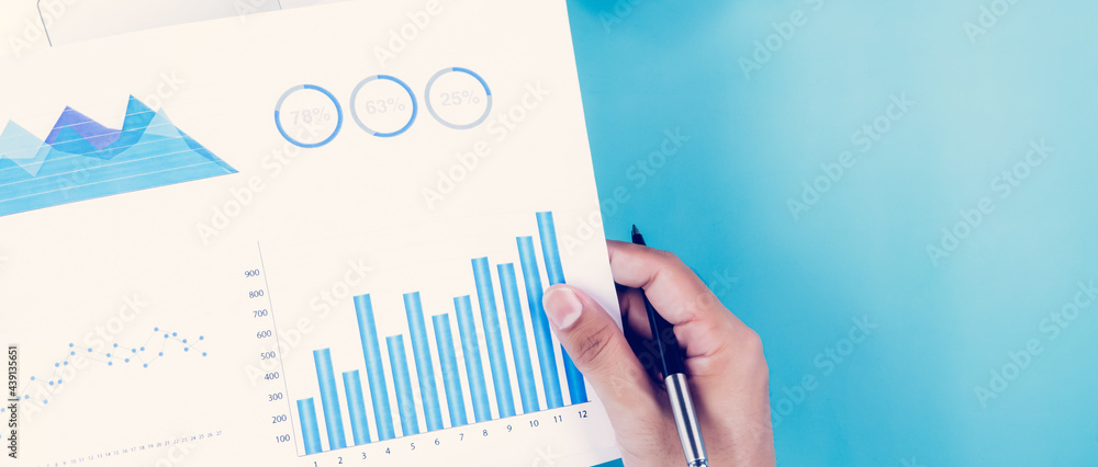 Aufkleber hand of businessman holding documents report statistic financial with graph and chart and laptop com