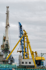 Fototapeta na wymiar Large cranes in the river port. Outdoors, day light Front view
