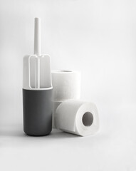 White and gray plastic toilet brush and  toilet paper on white background
