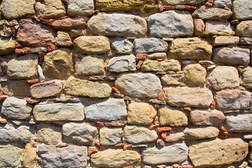 Old medieval italian stone wall, built with blocks, recently restored