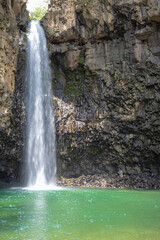 주상절리 절벽 사이로 쏟아지는 폭포와 에메랄드 빛 물