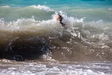 Fotobehang swim in big sea waves with foam near the shore, horizontal © Nataliia Makarovska