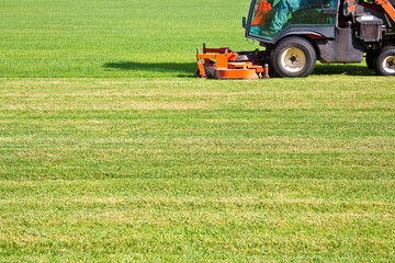 Ride on lawn mower cutting fresh grass - Image with copy space