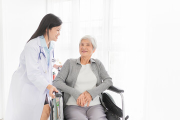 close up old asian patient sitting on wheelchair, old female talk about disease symptoms and treatment plan, happy hospital, rehabilitation activity, elderly healthcare promotion