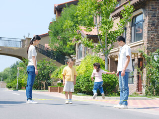 Happy family of four skipping rope outdoors