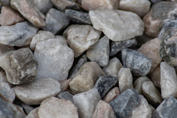 Raw rocks and minerals as natural stones background with crushed and rough material at a rough coast or rocky beach show nuggets and sandstones in harmonic pastel colors as natural mineral background