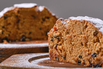 Two half of fresh perfect muffin cake with raisins decorated icing sugar on the wooden plates. Shallow depth of field
