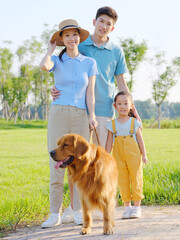 Happy family of three and pet dog in the park