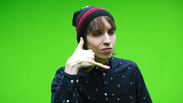 Young man doing call me symbol against a removable chroma key background