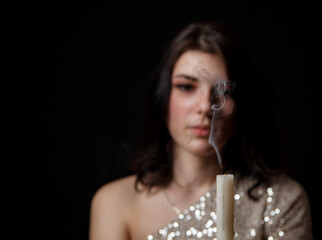 Obraz premium portrait of a young beautiful girl with candle in studio