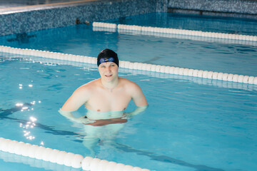 A young athlete trains and prepares for swimming competitions in the pool. Healthy lifestyle.