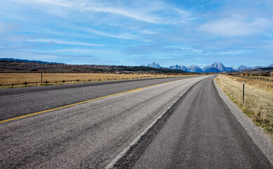 Fototapeta na wymiar Road with a diminishing perspective leading through the dramatic Wyoming landscape.