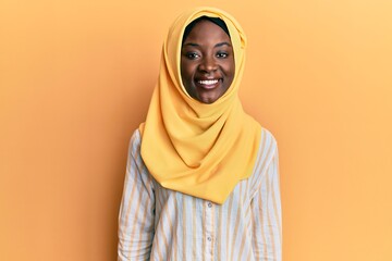 Beautiful african young woman wearing traditional islamic hijab scarf with a happy and cool smile on face. lucky person.