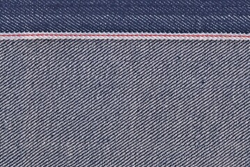 raw denim selvage dark blue fabric background texture.