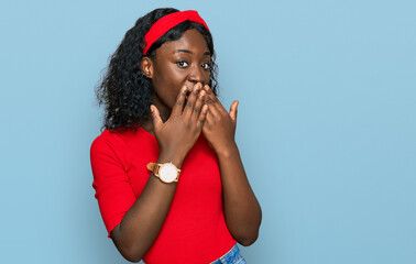 Beautiful african young woman wearing casual clothes laughing and embarrassed giggle covering mouth...