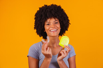 afro woman holding whitening plate. Invisible device.