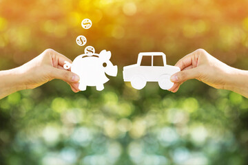 Woman hand holding a car and piggy bank and dollar coin model made of paper art filed together on...