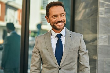 Middle age businessman smiling happy standing at the city.