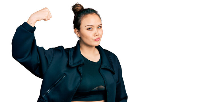 Young hispanic girl wearing sportswear strong person showing arm muscle, confident and proud of power