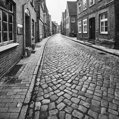 Fototapeta premium Cobbled streets and brick houses in the historic old town of Lauenburg in Germany, black and white