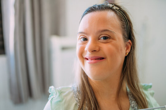 Close Up Portrait Of Friendly Young Latin Woman With Down Syndrome.