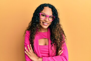 Fototapeta premium Young latin woman wearing business style and glasses happy face smiling with crossed arms looking at the camera. positive person.