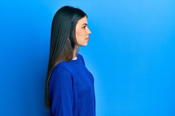 Young hispanic woman wearing casual clothes looking to side, relax profile pose with natural face with confident smile.