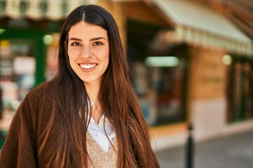 Obraz premium Young hispanic woman smiling happy standing at the city.