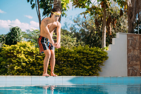 Latino down syndrome boy swimming in the pool. Disabled Brazilian.
