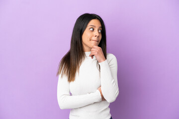 Young caucasian woman isolated on purple background having doubts and thinking