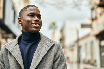 Obraz premium Young african american man smiling happy standing at the city