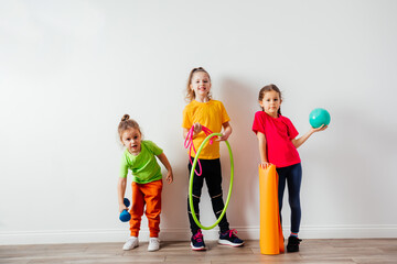 Sportive kids in colorful t-shirts posing with sport equipment