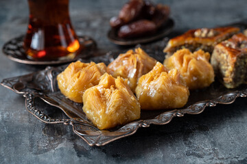 Turkish tea in traditional glass with baklava  on dark background