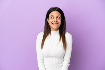 Young caucasian woman isolated on purple background having doubts while looking up