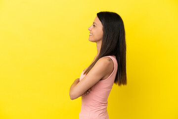 Young caucasian woman isolated on yellow background in lateral position