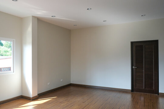 brown door close with white wall in new house. wooden laminate floor in living room.