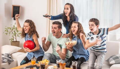 Fototapeta Raving fans cheering sports, as family of five watch football, match on the TV at home, screaming from joy obraz