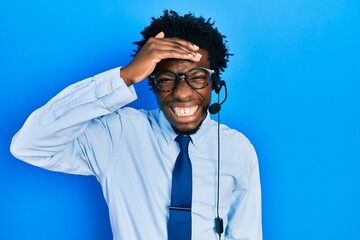 Young african american man wearing call center agent headset stressed and frustrated with hand on head, surprised and angry face