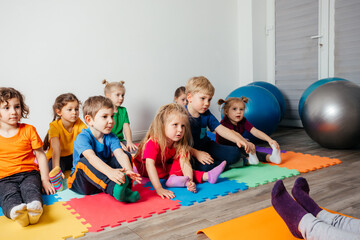 Children exercising while physical education lesson at preschool