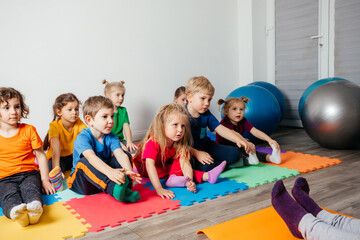 Children exercising while physical education lesson at preschool