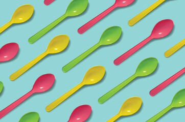 Plastic spoons pattern on light blue background.