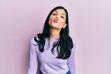 Fototapeta premium Young hispanic woman wearing casual clothes looking at the camera blowing a kiss on air being lovely and sexy. love expression.