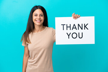 Young woman over isolated background holding a placard with text THANK YOU with happy expression