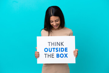 Young woman over isolated background holding a placard with text Think Outside The Box