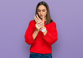 Beautiful brunette woman wearing casual winter sweater suffering pain on hands and fingers, arthritis inflammation