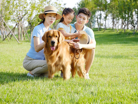 Happy family of three and pet dog in outdoor photo
