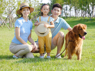 Happy family of three and pet dog in outdoor photo