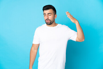 Naklejka premium Caucasian man over isolated blue background with tired and sick expression