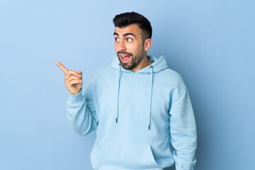 Caucasian man over isolated blue background intending to realizes the solution while lifting a finger up