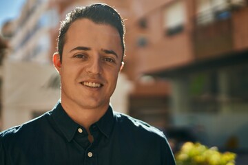 Fototapeta premium Young hispanic man smiling happy standing at the city.